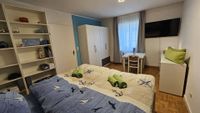 Maritimes Schlafzimmer mit Doppelbett, TV, Sitzgelegenheit und Kleiderschrank